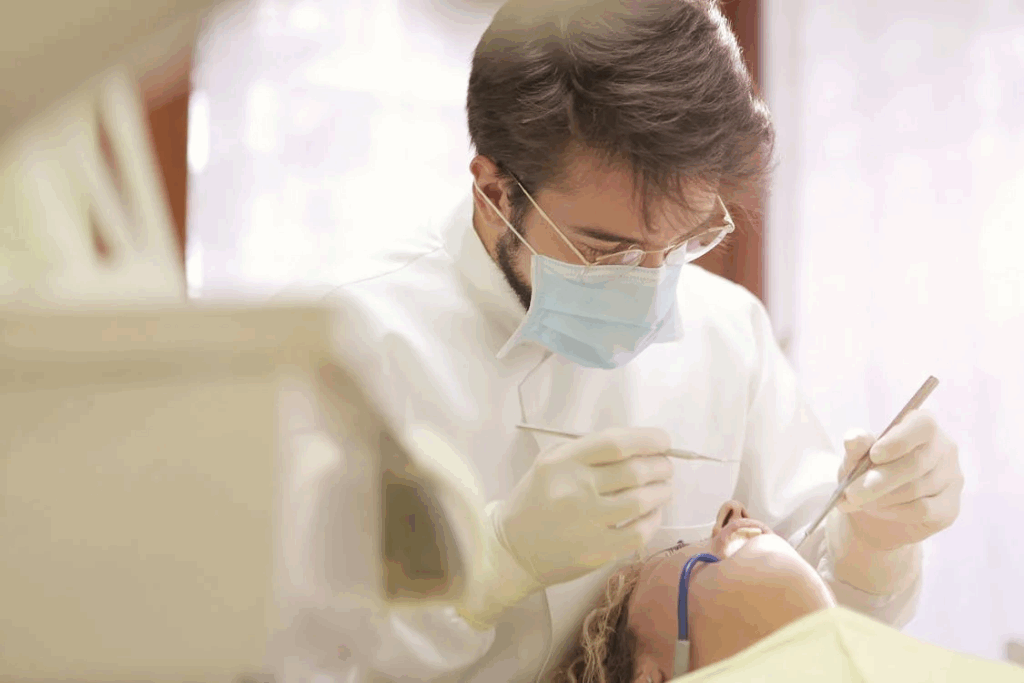 a young dentist performing a dental cleaning on his patient